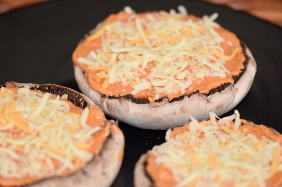 Rezepte: Kleinigkeiten: Portobello-Pizza, Portobellomit Paprika-Tomaten-Sauce gefüllt und mit Käse bestreut, ungebacken