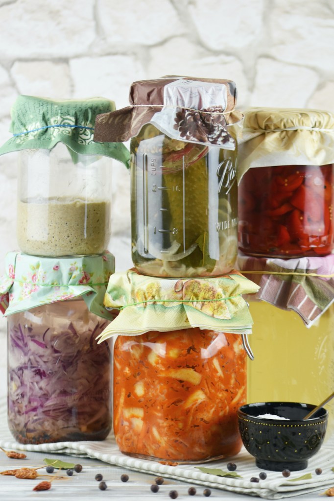 Einmachgläser gefüllt mit verschiedenen Fermenten der wilden Fermentation. Hintergrund hell.