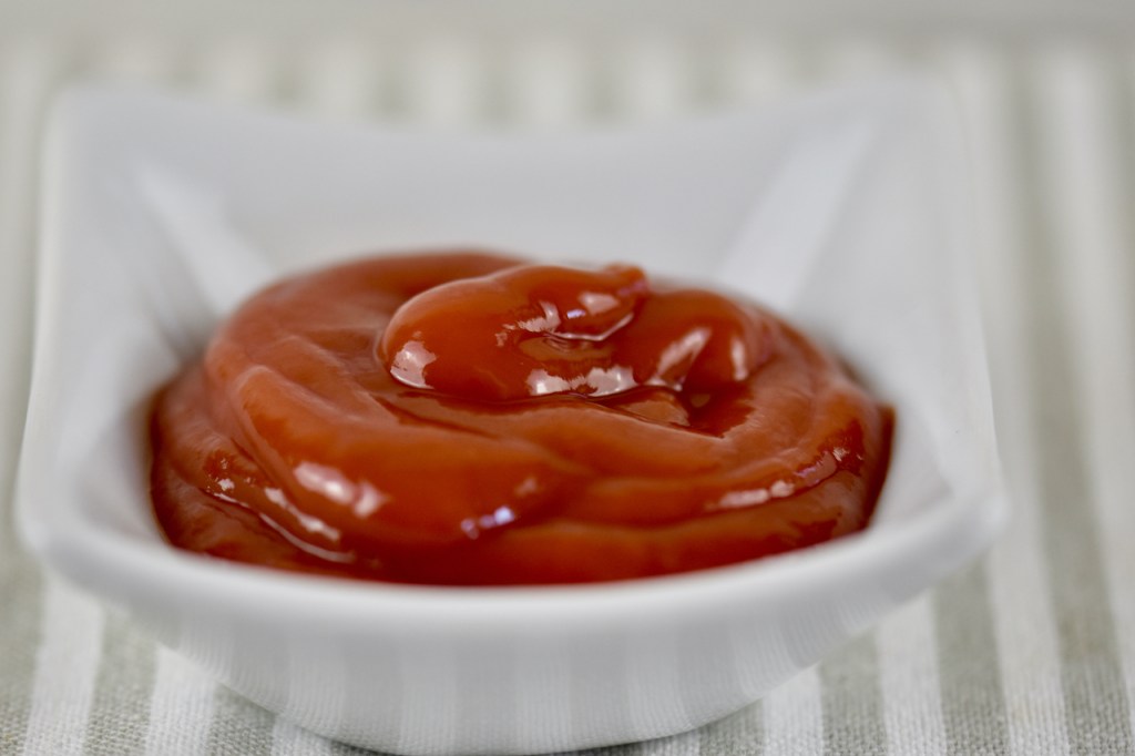 Ketchup in weißem Porzellan-Schälchen.