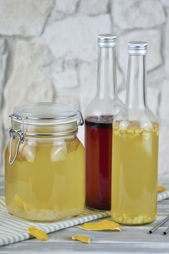 Wasserkefir im Einmachglas und in 2 Flaschen. Im Einmachglas ist der Ansatz und in den Flaschen die Zweitfermentation. In einer Flasche ist Ingwer und in einer sind Blaubeeren zugesetzt.