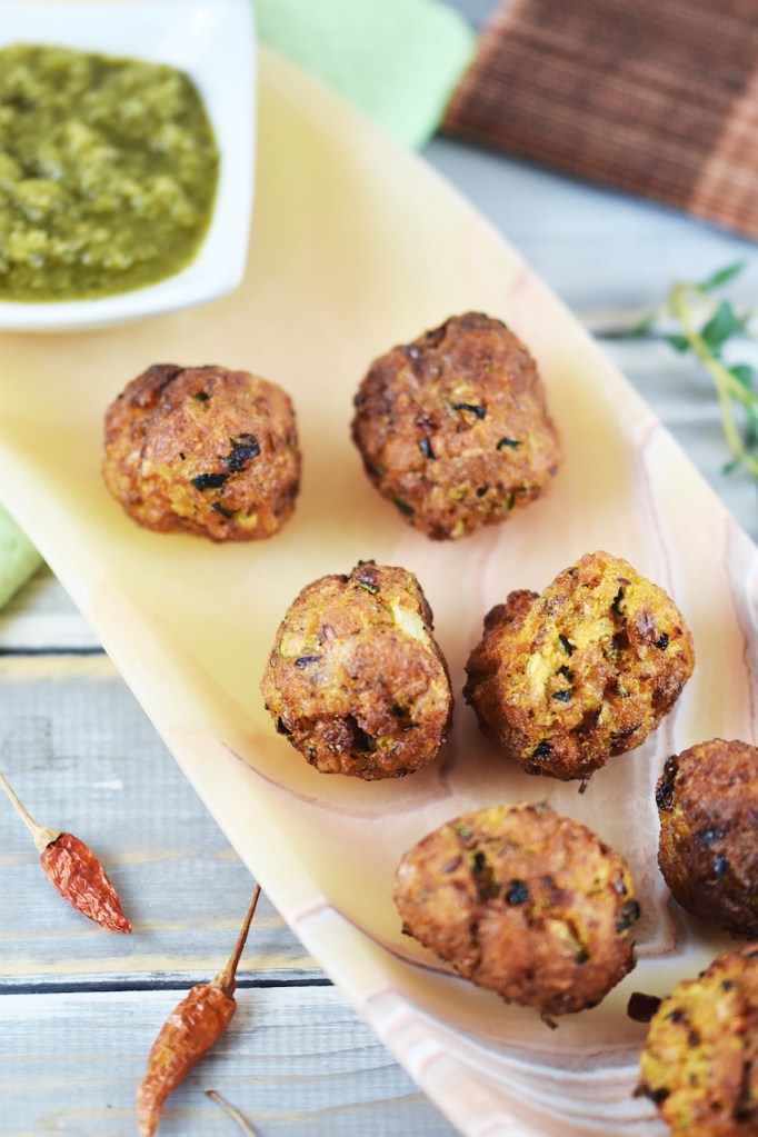 Möhren-Zucchini-Bällchen mit Jalapeño-Salsa auf länglicher Schale aus orangem Onyx.