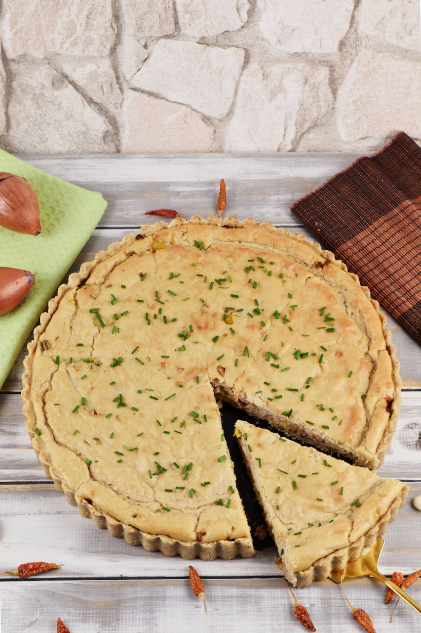 Runde Quiche Lorraine mit Lauch. Hintergrund hell.