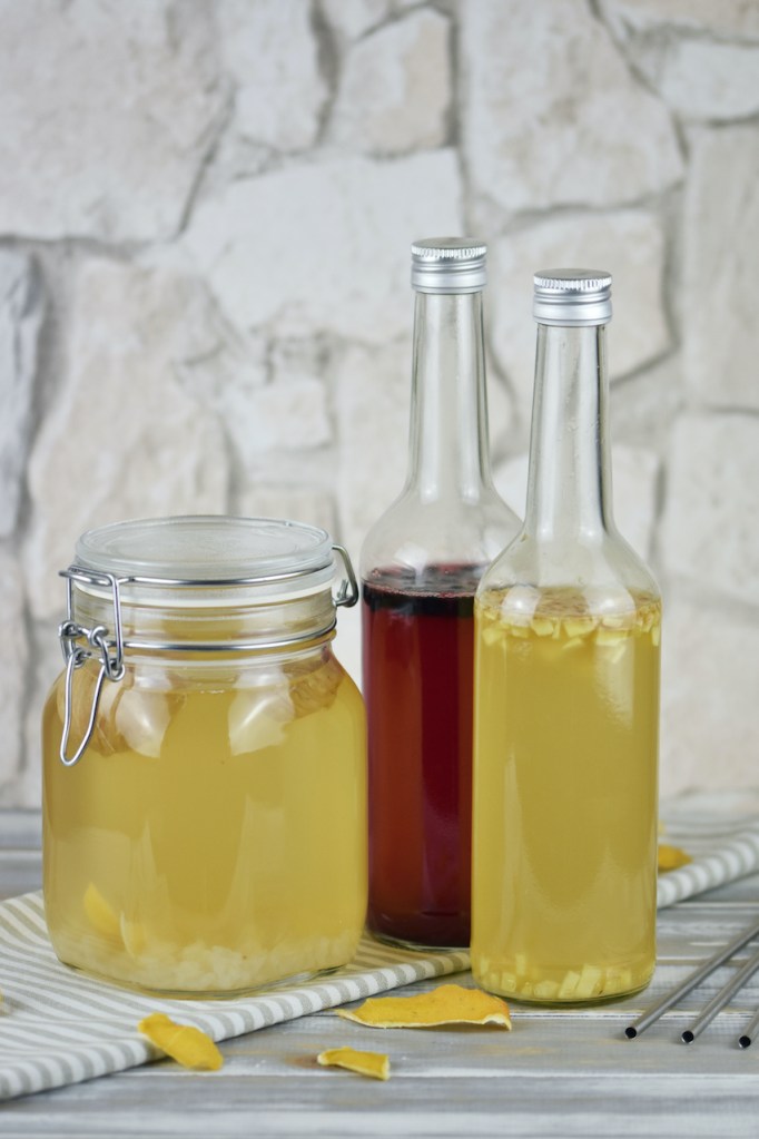 Wasserkefir im Einmachglas und in 2 Flaschen. Im Einmachglas ist der Ansatz und in den Flaschen die Zweitfermentation. In einer Flasche ist Ingwer und in einer sind Blaubeeren zugesetzt.
