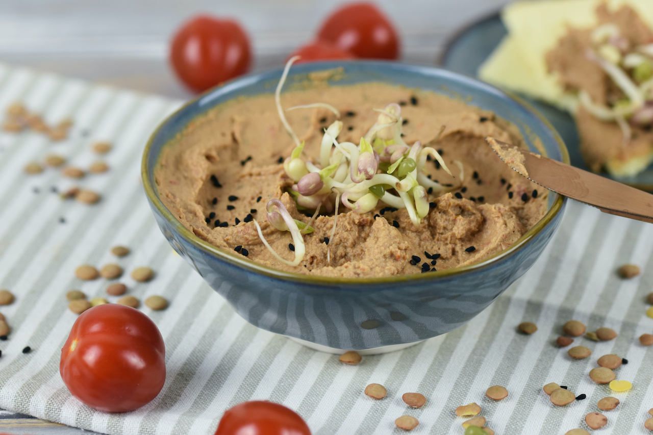 Linsen-Tomaten-Aufstrich mit Tahini in einer grauen Schale. Hintergrund hell.