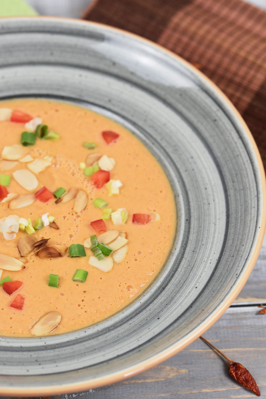 Tomatencremesuppe in grauem Teller. Der Teller ist nur halb zu sehen. Hintergrund hell.