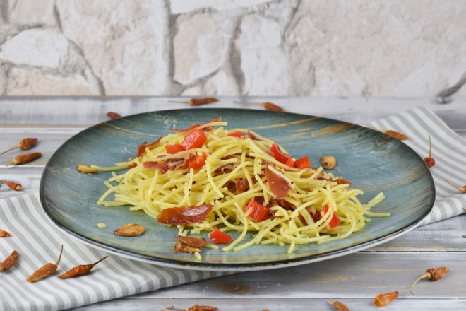 Spaghetti aglio e olio e peperoncino auf einem türkisen Teller.