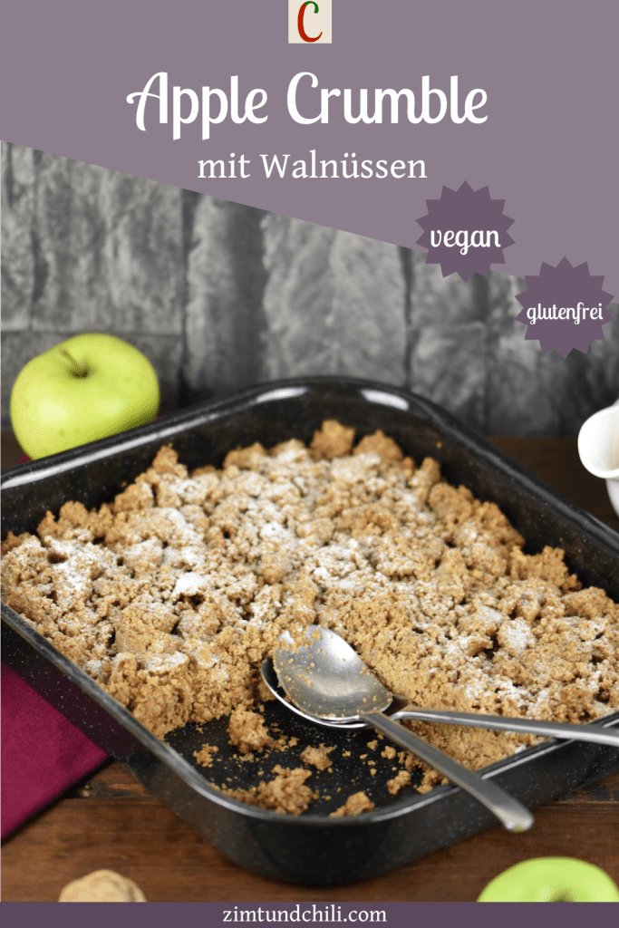 Apple Crumble mit Walnüssen und Haferflocken in einer Auflaufform. Hintergrund dunkel. Beschrifteter Pin.