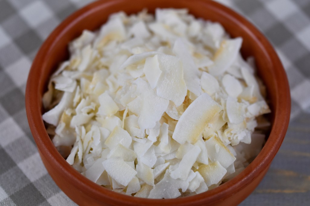 Kokoschips in Tonschale. Hintergrund hell.