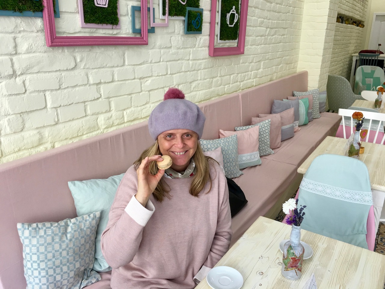 Über mich - Ich in einem Cafe mit Macaron in der Hand