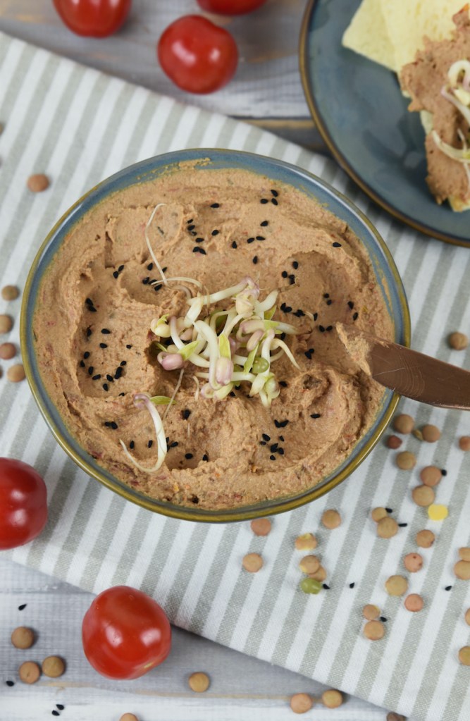 Linsen-Tomaten-Aufstrich mit Tahini in einer grauen Schale. Hintergrund hell.