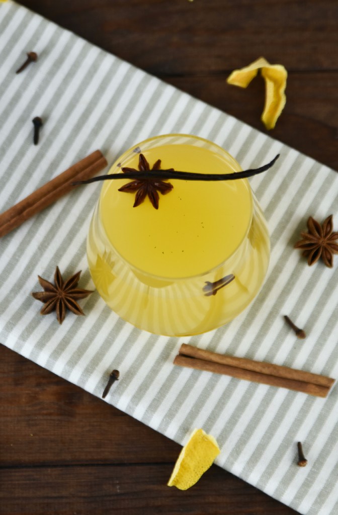 Weißer Glühwein mit Vanille und Orange in einem Glas ohne Stiel.