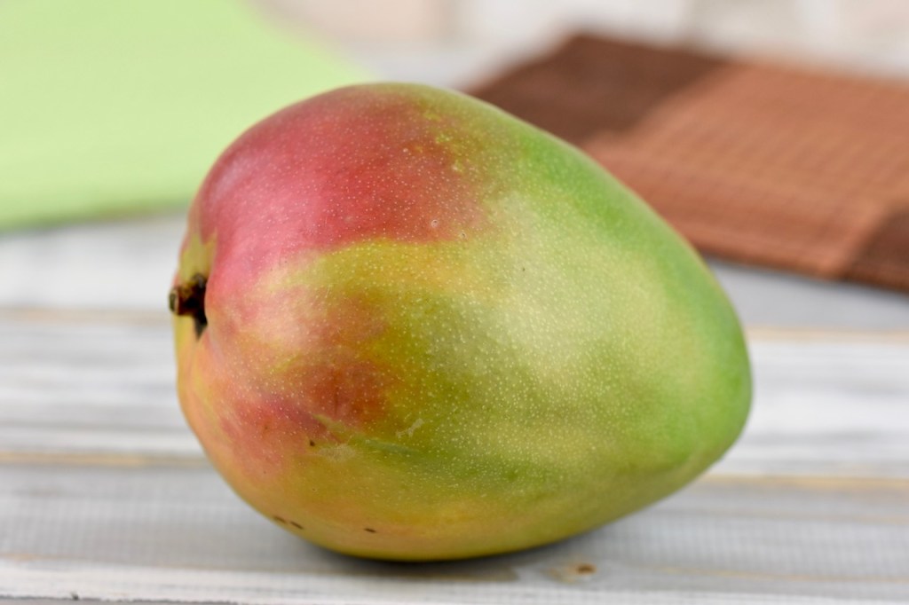 Mango auf hellem Holztisch.