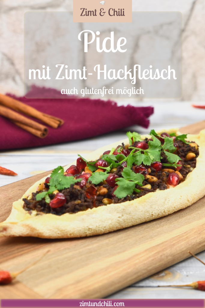 Pide mit Zimt-Hackfleisch, garniert mit Koriandergrün, auf einem Holzbrett. Beschrifteter Pin.