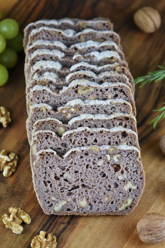 Glutenfreies Walnussbrot aufgeschnitten auf Holzbrett.