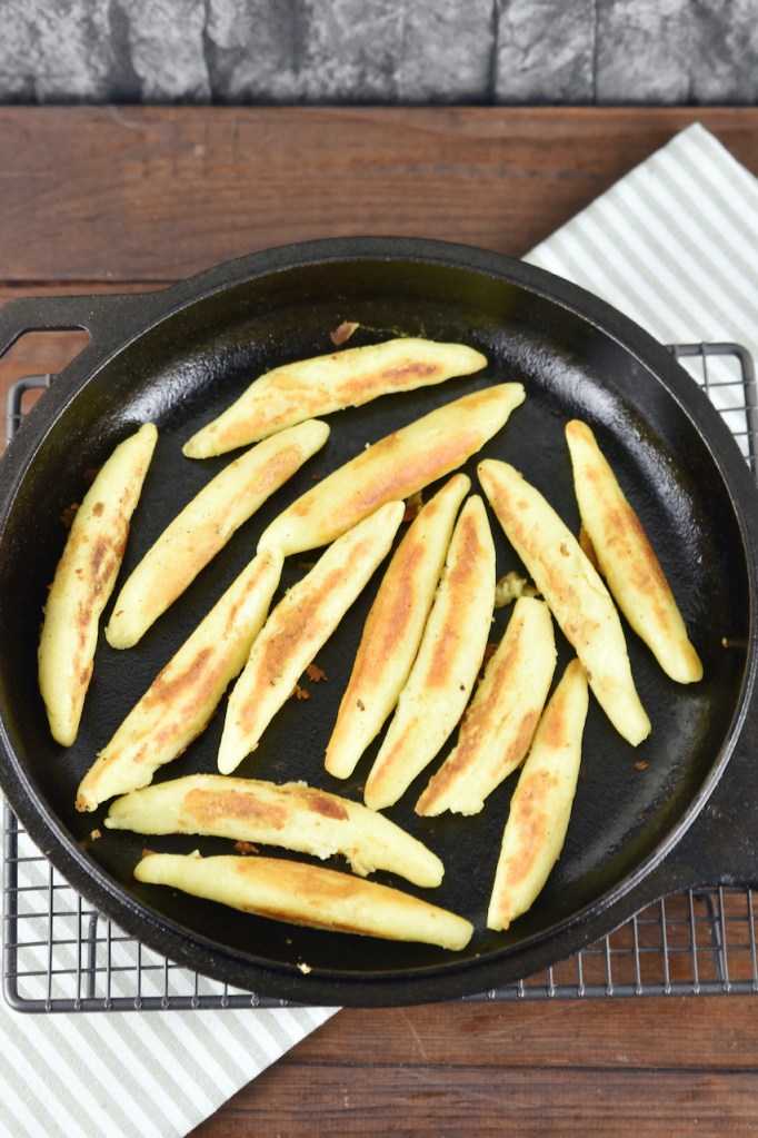 Glutenfreie Schupfnudeln angebraten in einer gußeisernen Pfanne.