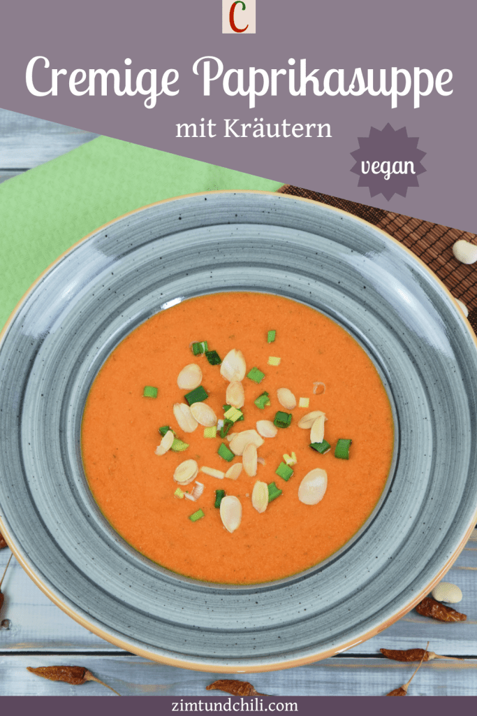 Cremige Paprikasuppe mit Kräutern in einem grauen Teller. Beschrifteter Pin.