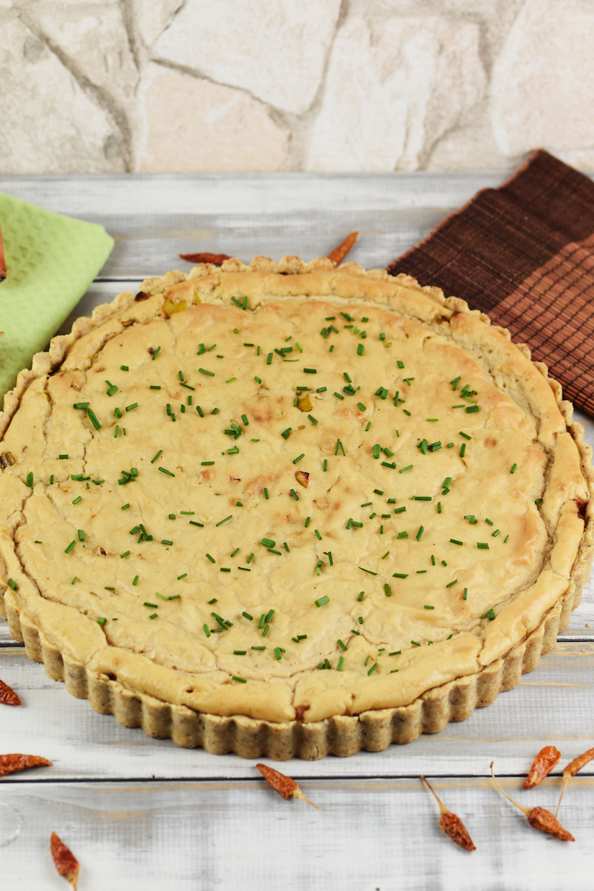 Runde Quiche Lorraine mit Lauch. Hintergrund hell.