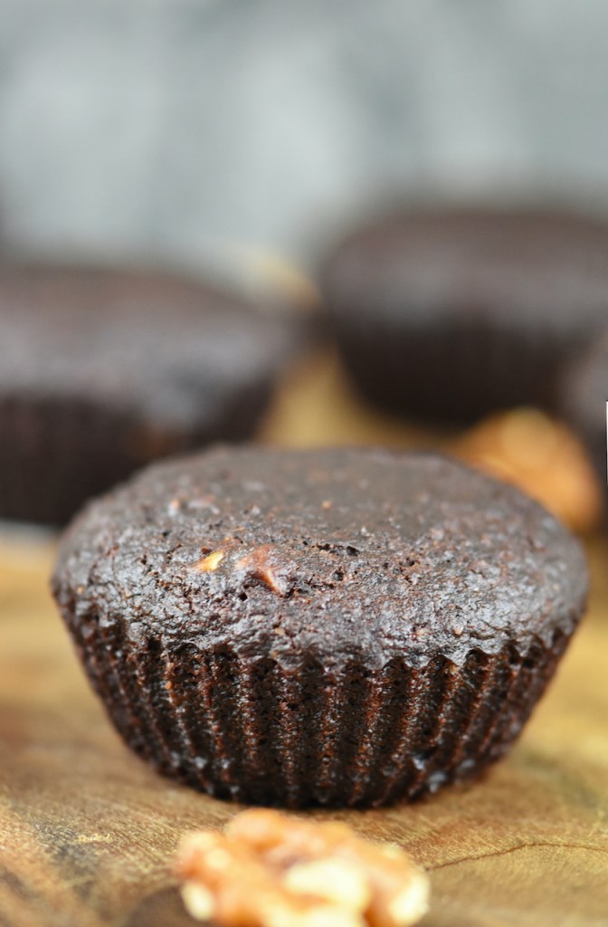 Saftige Brownies mit Walnüssen auf Holzbrett. Hintergrund dunkel.