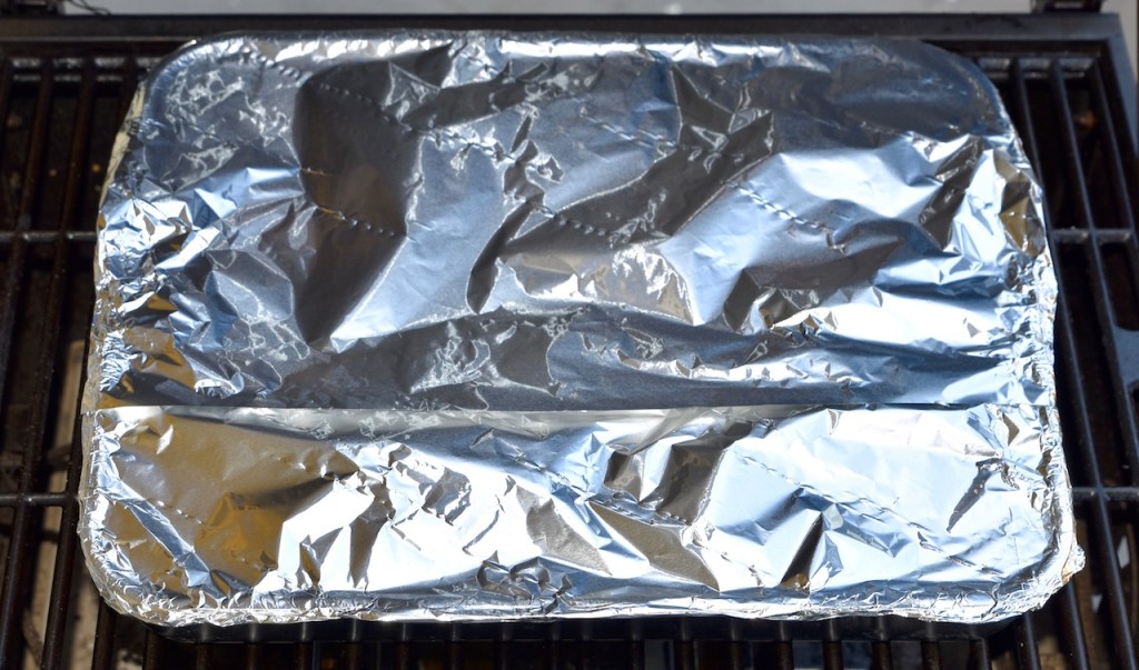 Ribs vom Holzkohlegrill eingepackt in Alufolie für die Dämpfphase.