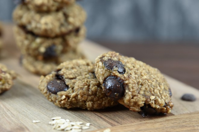 Weiche Chocolate Chip Cookies auf Holzbrett. Hintergrund dunkel.