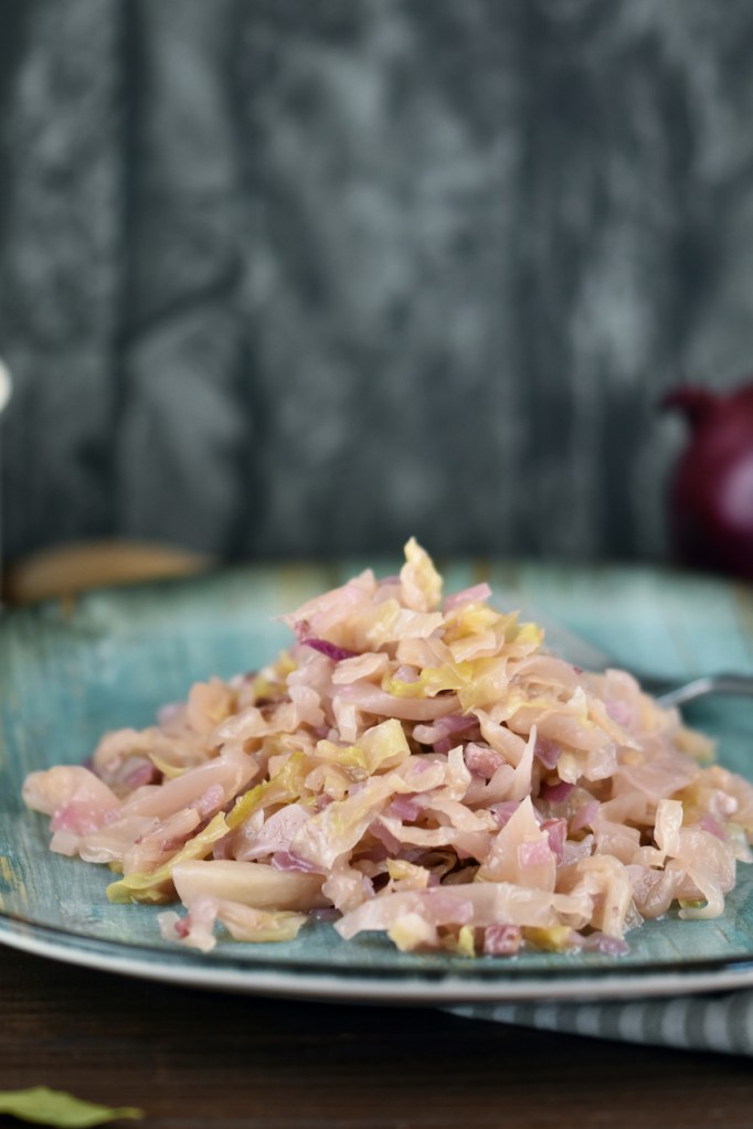 Sauerkraut geschmort auf einem blau-grünem Teller.