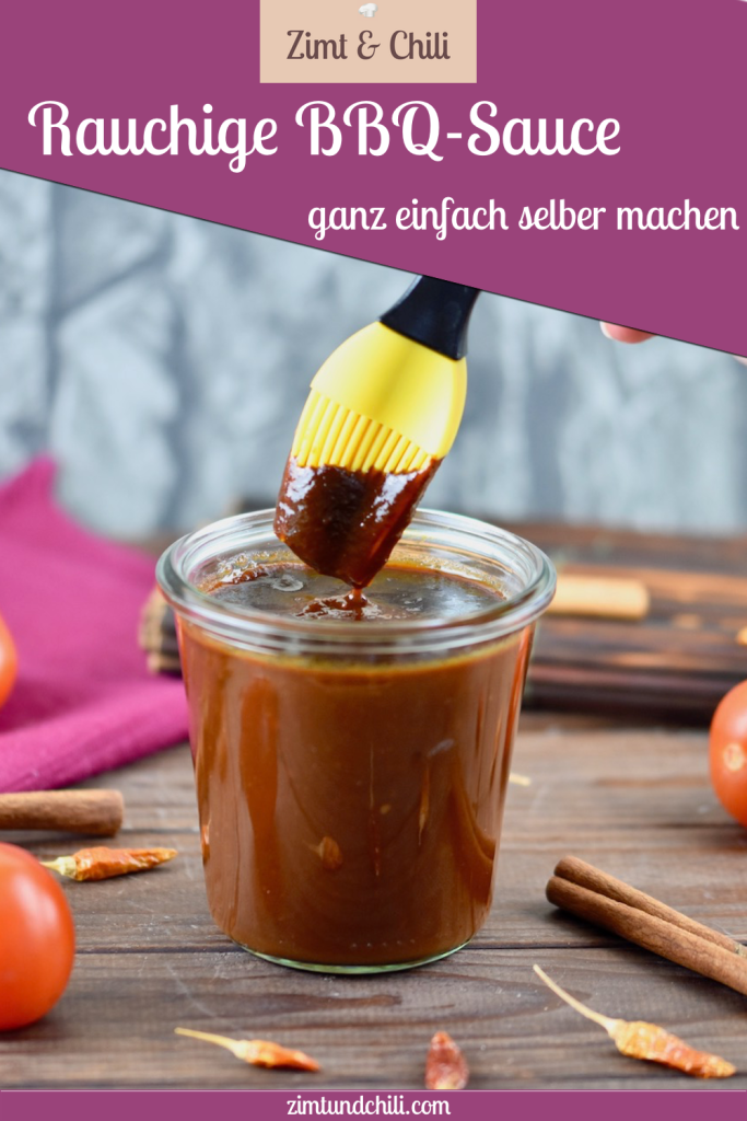 Rauchige BBQ-Sauce in einem Glas. Ein Pinsel mit gelben Silikonborsten wird in die Sauce getunkt. Hintergrund dunkel. Pin beschriftet.