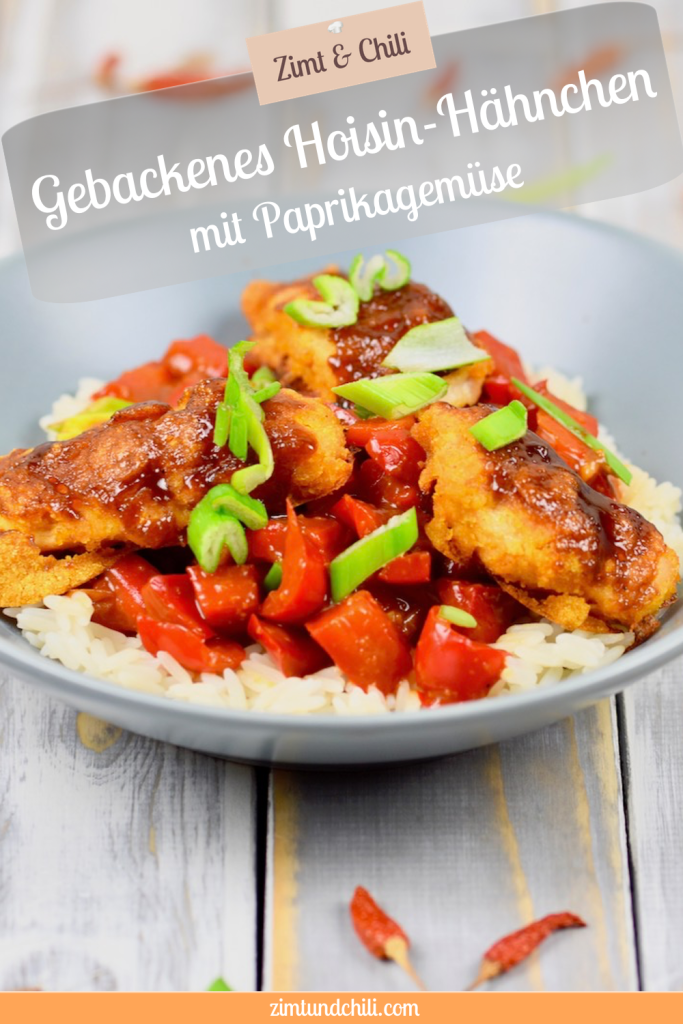 Gebackenes Hoisin-Hähnchen auf Paprikagemüse mit Reis in hellgrauem Teller. Der Teller steht auf einer weißen Holzfläche. Beschrifteter Pin.