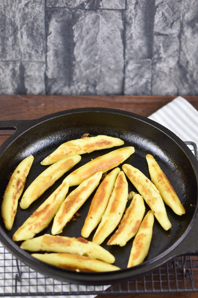 Glutenfreie Schupfnudeln angebraten in einer gußeisernen Pfanne.