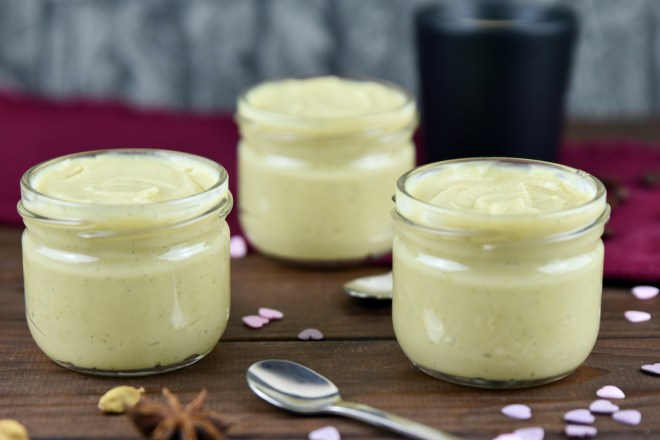 Vanillepudding selber machen und in Gläser abgefüllt. Hintergrund dunkel.