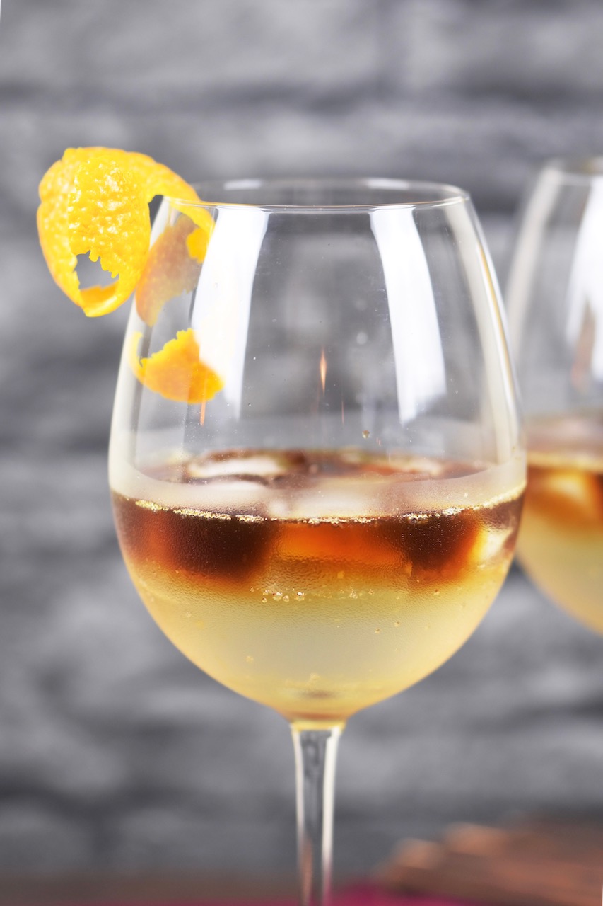 Espresso Tonic im Weinglas. Hintergrund dunkel.