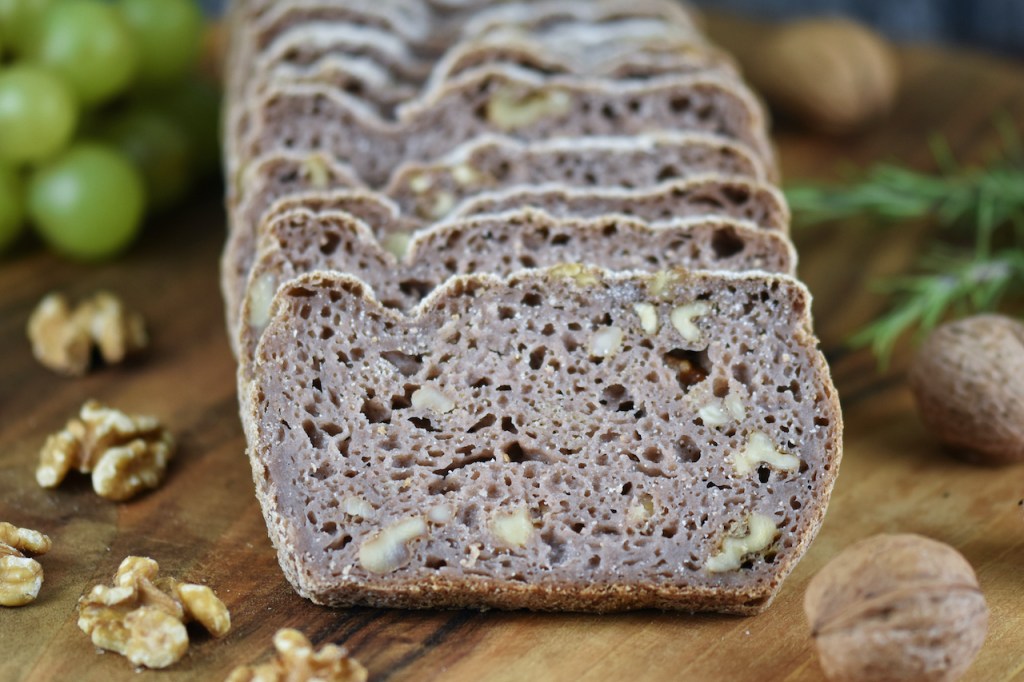 Glutenfreies Walnussbrot aufgeschnitten auf Holzbrett.