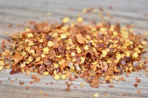 rote Chiliflocken lose, Hintergrund Holz