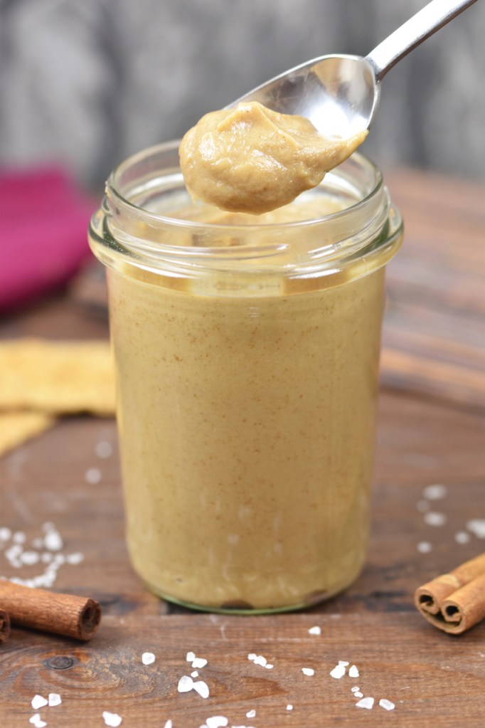 Salted Caramel Aufstrich in einem Glas. Hintergrund dunkel.