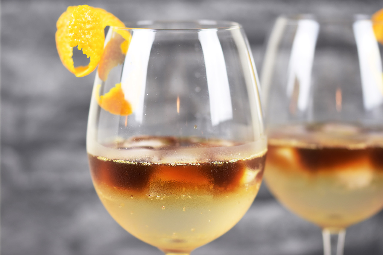 Zwei Espresso Tonic in Weingläsern. Hintergrund dunkel.