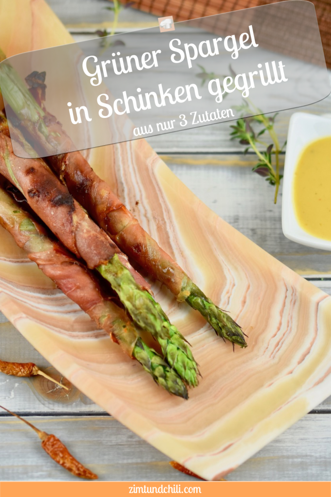 Grüner Spargel in Schinken gegrillt auf länglicher Schale aus Onyxmarmor. Hintergrund hell. Hochkant-Pin - beschriftet.