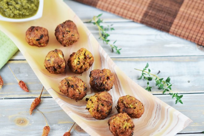 Möhren-Zucchini-Bällchen mit Jalapeño-Salsa auf länglicher Schale aus orangem Onyx.