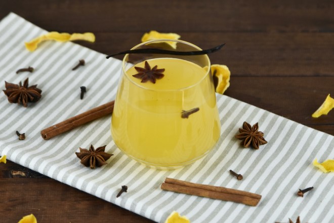 Weißer Glühwein mit Vanille und Orange in einem Glas ohne Stiel.