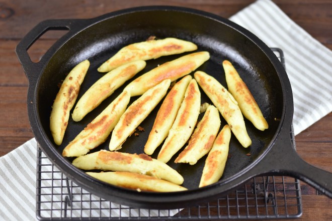 Glutenfreie Schupfnudeln angebraten in einer gußeisernen Pfanne.