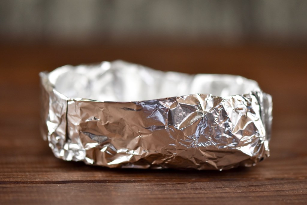 selbst gefaltetes Schiffchen aus Alufolie. Hintergrund dunkel.