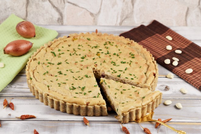 Runde Quiche Lorraine mit Lauch. Hintergrund hell.