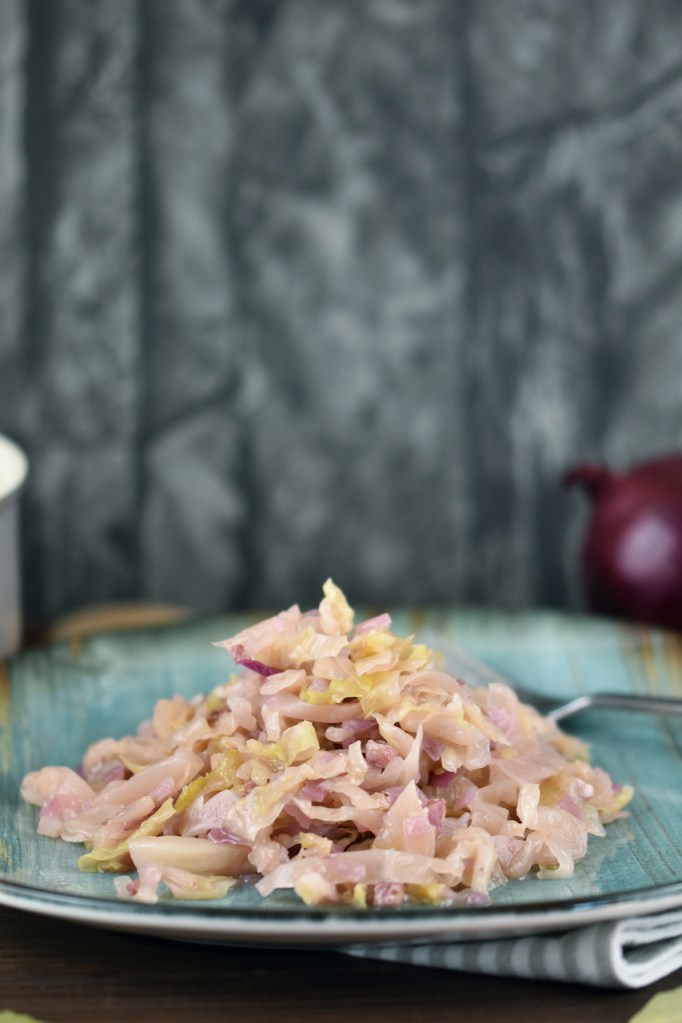 Sauerkraut geschmort auf einem blau-grünem Teller.