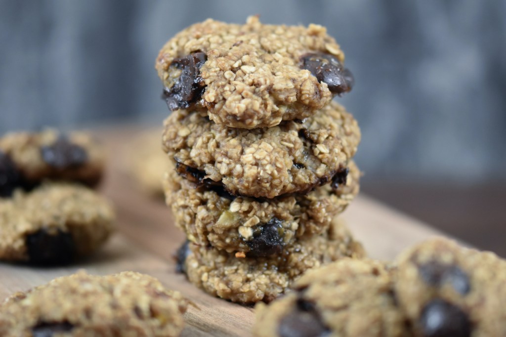 Weiche Chocolate Chip Cookies auf Holzbrett. Hintergrund dunkel.