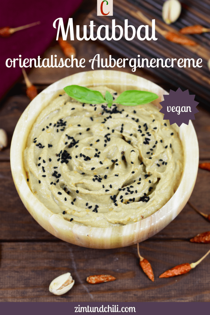 Orientalisches Mutabbal in einer Schale garniert mit Schwarzkümmelsamen und Basilikum. Hintergrund dunkel. Beschrifteter Pin.