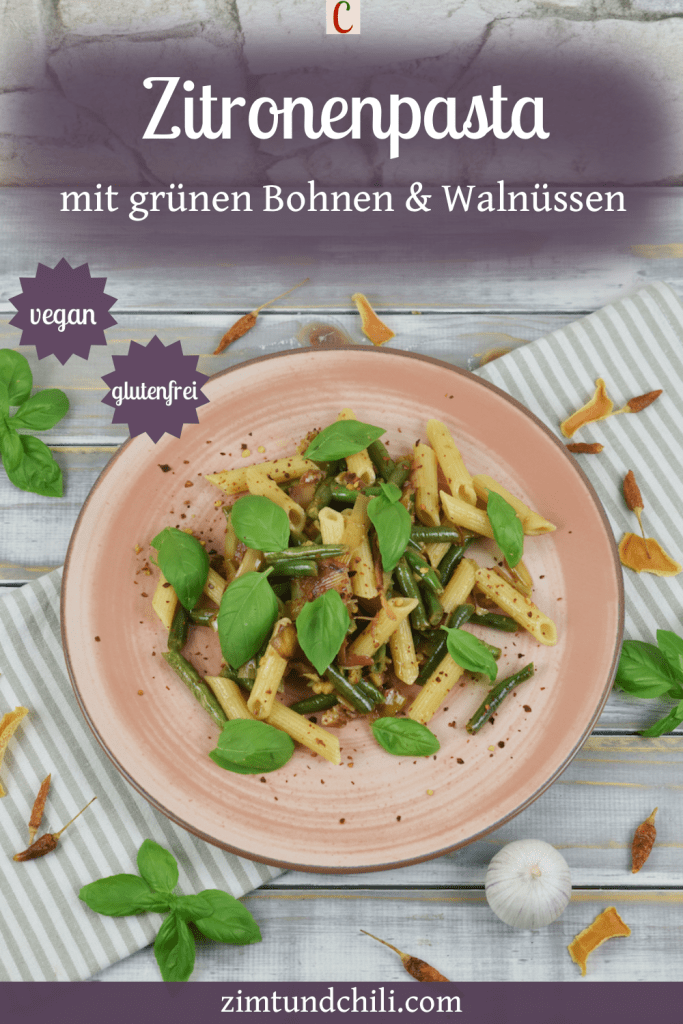Zitronenpasta mit grünen Bohnen und Walnüssen auf einem rosa Teller. Beschrifteter Pin.