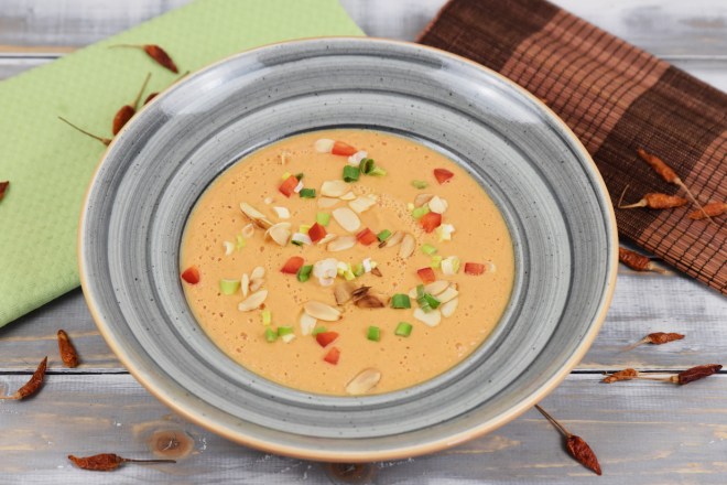 Tomatencremesuppe in grauem Teller. Hintergrund hell.