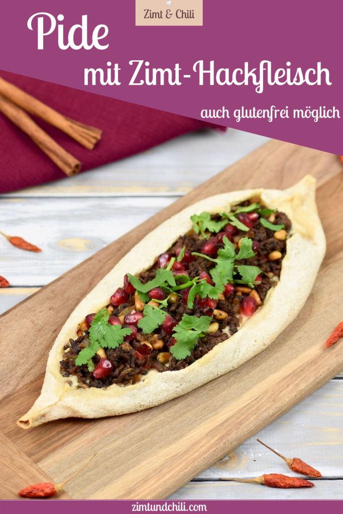 Pide mit Zimt-Hackfleisch, garniert mit Koriandergrün, auf einem Holzbrett. Beschrifteter Pin.