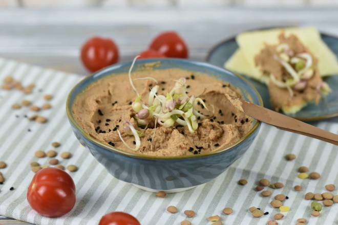 Linsen-Tomaten-Aufstrich mit Tahini in einer grauen Schale. Hintergrund hell.