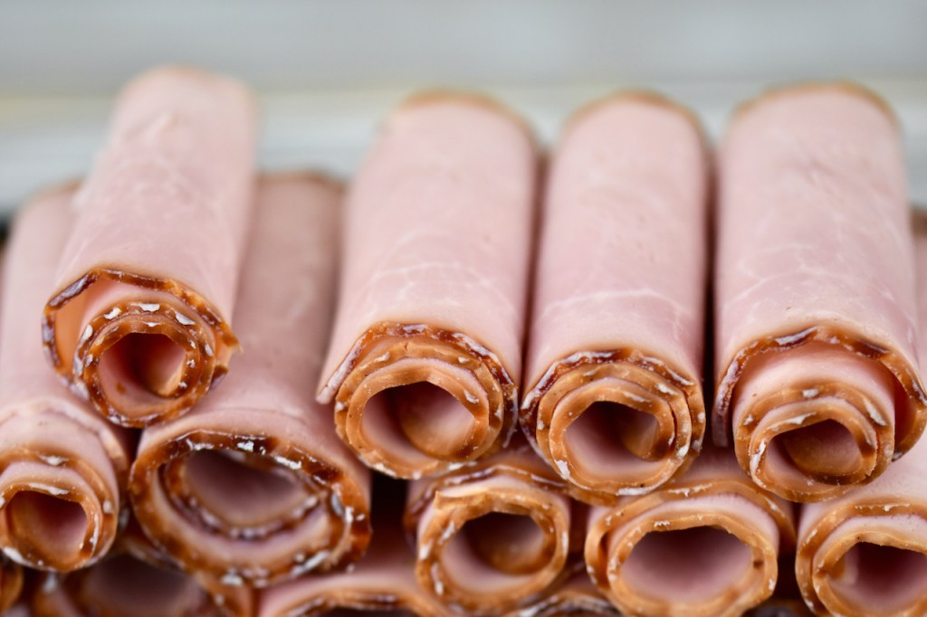 Aufgerollte Pastrami-Scheiben, die aufeinander gestapelt sind.