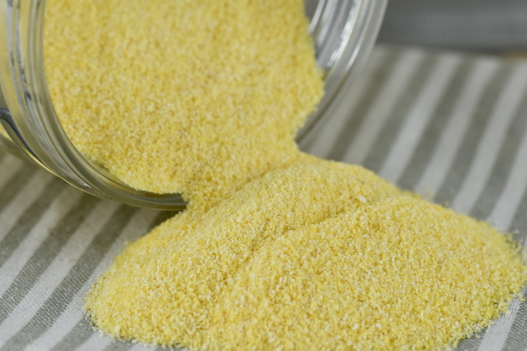 Polenta, Maisgrieß in einem liegenden Glas. Etwas ist herausgefallen.