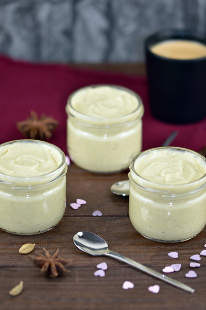 Vanillepudding selber machen und in Gläser abgefüllt. Hintergrund dunkel.